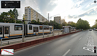 Captură de ecran de pe Google Maps (mod Street View), reprezentând o stație de tramvai (nemodernizată) de pe linia 19, pe bulevardul Camil Ressu. Se poate observa tabla ruginită de la acoperișul stației și pavajul spart și nereparat de pe peron. Imagine realizată de Google Maps în august 2023.